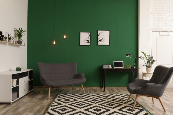 Modern living room interior with workplace near green wall